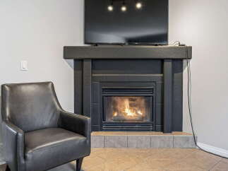 Cozy up by the fireplace in this inviting living space, perfect for relaxing evenings.