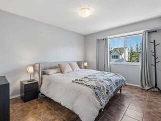 This inviting bedroom features a comfortable king-size bed with plush pillows and a decorative throw blanket, perfect for relaxation.
