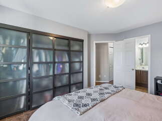 This bedroom features a spacious closet with modern sliding doors, offering ample storage and a sleek aesthetic.