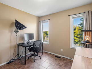 This room features a dedicated workspace with a computer setup and a professional lighting rig, perfect for content creation or remote work.