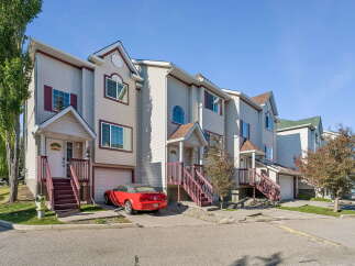 Discover this charming townhouse complex featuring multiple units with attached garages and individual driveways.