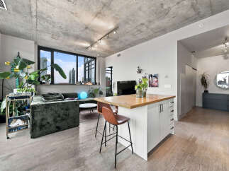 Experience modern urban living in this stylish apartment featuring an open-concept living and kitchen area.