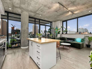 Experience modern urban living in this stylish apartment featuring an open-concept layout with a sleek kitchen island and a spacious living area.