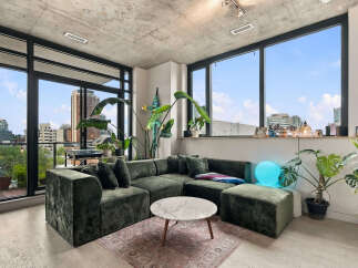 Experience modern urban living in this stylish apartment featuring a spacious sectional sofa and a marble coffee table.