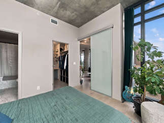 Experience modern urban living in this stylish bedroom featuring a spacious walk-in closet and an en-suite bathroom.