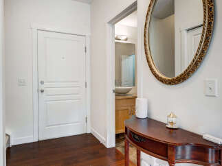 Step into a welcoming entryway featuring a sleek white door and rich hardwood floors.