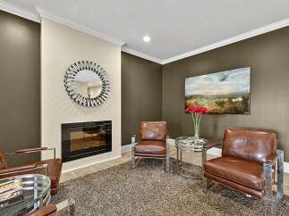 Experience luxury living in this sophisticated sitting area, featuring plush brown leather armchairs complemented by a sleek chrome and glass coffee table.