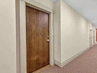 Step into this inviting hallway featuring a beautifully crafted wooden door, marked with the number 307.