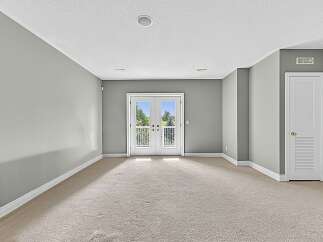 Step into this spacious room, featuring a neutral color palette and plush carpeting for a cozy feel.