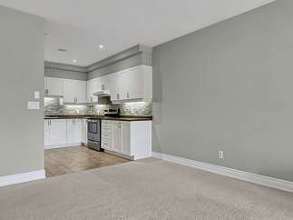 Discover this modern kitchen featuring sleek white cabinetry and a stylish mosaic tile backsplash.