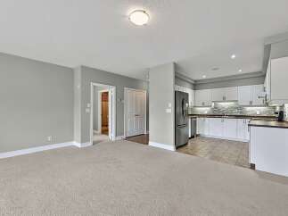 Step into this inviting living space featuring plush carpeting and neutral gray walls, creating a serene atmosphere.