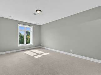 This spacious room features a large window offering abundant natural light and a view of lush greenery.