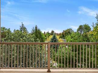 Enjoy the serene views from this balcony, overlooking a lush canopy of mature trees.