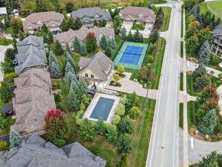 Experience luxury living in this stunning aerial view of a suburban neighborhood featuring elegant homes with well-maintained landscaping.