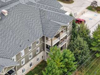 Experience modern living in this multi-story apartment building featuring a durable asphalt shingle roof and attractive siding.