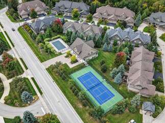 Discover luxury living in this stunning aerial view of a suburban neighborhood, showcasing elegant homes with manicured lawns and mature trees.