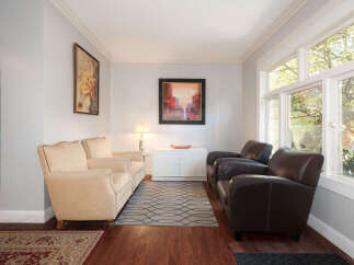 Step into this inviting living space, featuring a comfortable seating arrangement with two plush beige armchairs and two rich brown leather armchairs, perfect for relaxation.