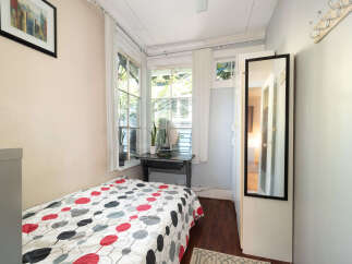 Discover this charming bedroom featuring a comfortable bed with a vibrant, patterned comforter.