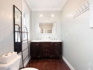 This charming bathroom features a spacious double vanity with dark wood cabinetry and a white countertop, perfect for shared use.