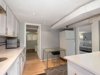 Discover this charming kitchen featuring white cabinetry and a sleek countertop.