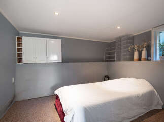 Discover this cozy bedroom featuring a comfortable bed with crisp white linens, perfect for relaxation.