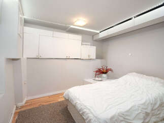 This cozy bedroom features a comfortable bed with crisp white linens, perfect for a restful night's sleep.
