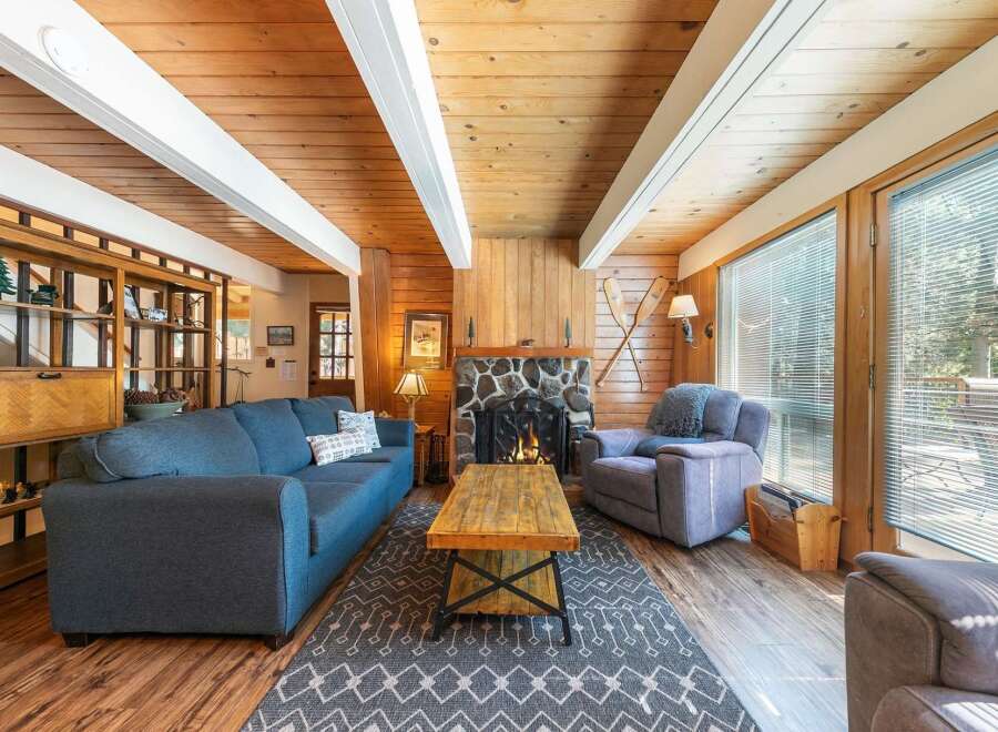 Cozy living room featuring a stone fireplace and a rustic wooden coffee table, perfect for gathering with loved ones.