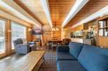 Experience cozy living in this charming cabin featuring a spacious open-concept living area with a rustic wood-paneled ceiling and exposed beams.