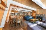 Experience cozy living in this charming A-frame cabin featuring a rustic stone fireplace and a warm, wood-paneled interior.