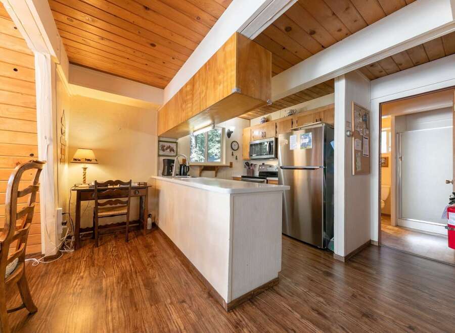 Discover this charming kitchen featuring a spacious island, stainless steel appliances, and ample wooden cabinetry.