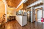 Discover this charming kitchen featuring a spacious island, stainless steel appliances, and ample wooden cabinetry.