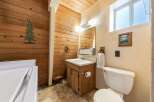 This rustic bathroom features warm wood paneling throughout, creating a cozy and inviting atmosphere.