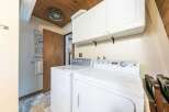 This laundry room features a white top-load washer and a white front-load dryer, perfect for handling all your laundry needs.