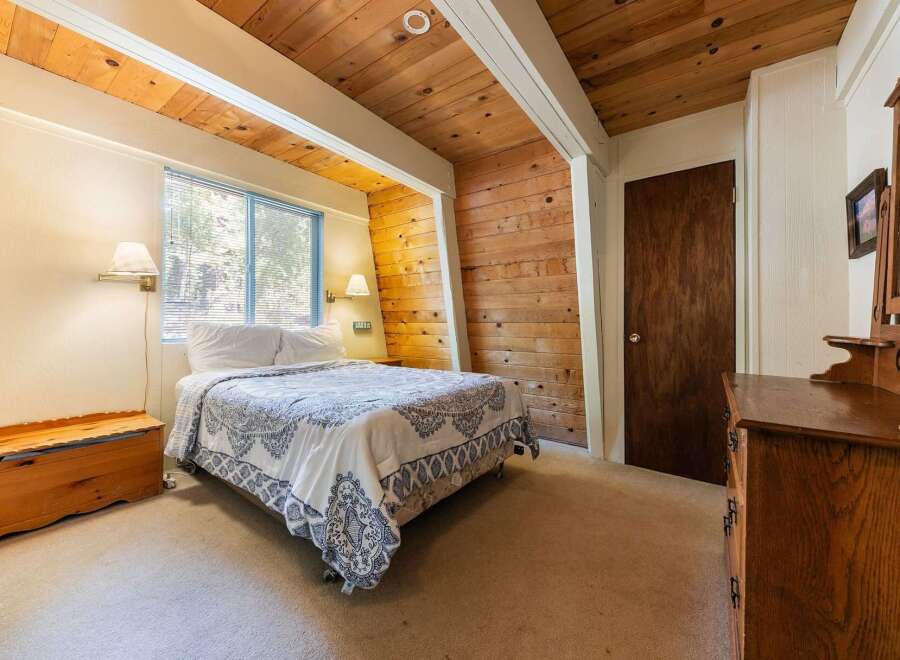 This charming bedroom features a comfortable queen-size bed adorned with a blue and white patterned comforter, perfect for a restful night's sleep.