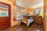 This cozy bedroom features a sturdy wooden bunk bed with blue bedding, perfect for accommodating guests or children.