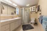 This bathroom features a spacious vanity with ample storage and a large mirror, perfect for your morning routine.