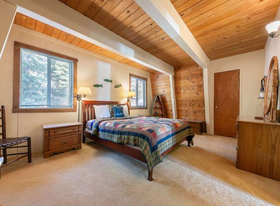 Experience rustic charm in this cozy bedroom, featuring a warm wooden ceiling and accent walls that create a cabin-like ambiance.