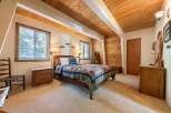 Experience rustic charm in this cozy bedroom, featuring a warm wooden ceiling and accent walls that create a cabin-like ambiance.