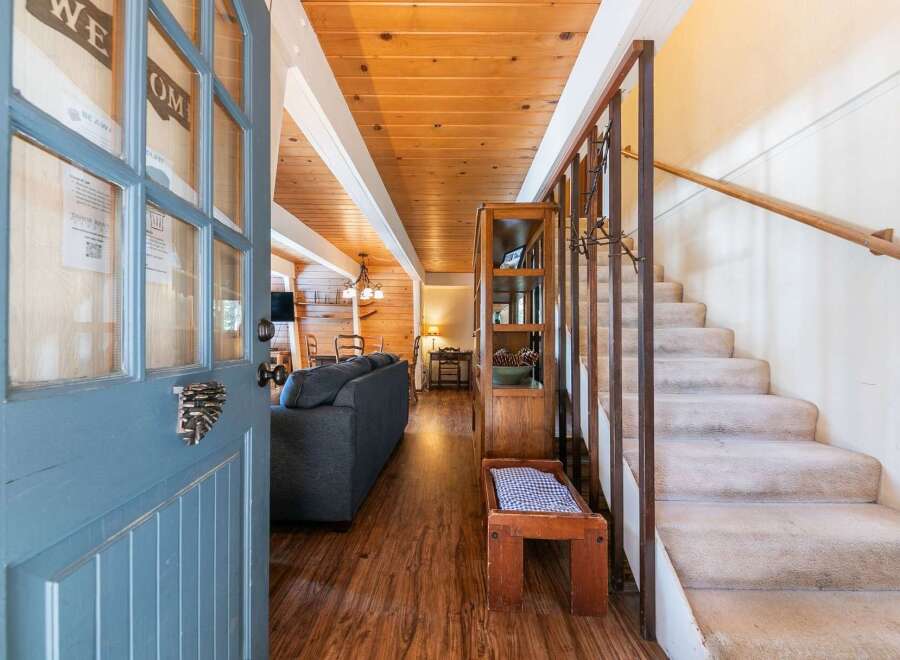 Step into a warm and inviting entryway featuring a rustic blue door with unique pinecone hardware.
