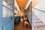 Step into a warm and inviting entryway featuring a rustic blue door with unique pinecone hardware.