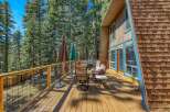 Enjoy outdoor living on this spacious wooden deck, perfect for entertaining or relaxing amidst a serene forest setting.