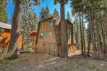 Nestled amongst tall pine trees, this charming A-frame cabin offers a rustic retreat.