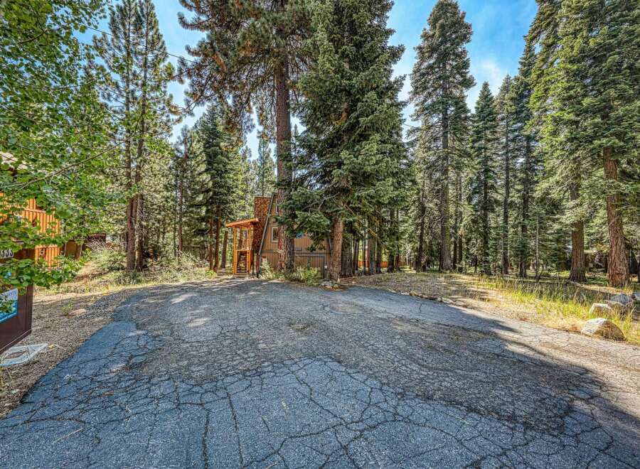 Nestled amongst towering pine trees, this charming A-frame cabin offers a serene mountain getaway.