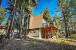 Nestled amongst tall pine trees, this charming A-frame cabin offers a serene mountain getaway.