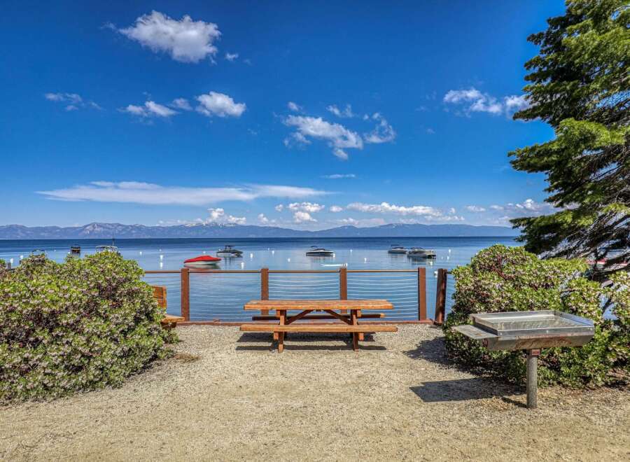 Enjoy breathtaking lake views from this picturesque picnic area, complete with a wooden picnic table and a built-in barbecue grill.