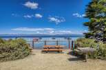 Enjoy breathtaking lake views from this picturesque picnic area, complete with a wooden picnic table and a built-in barbecue grill.
