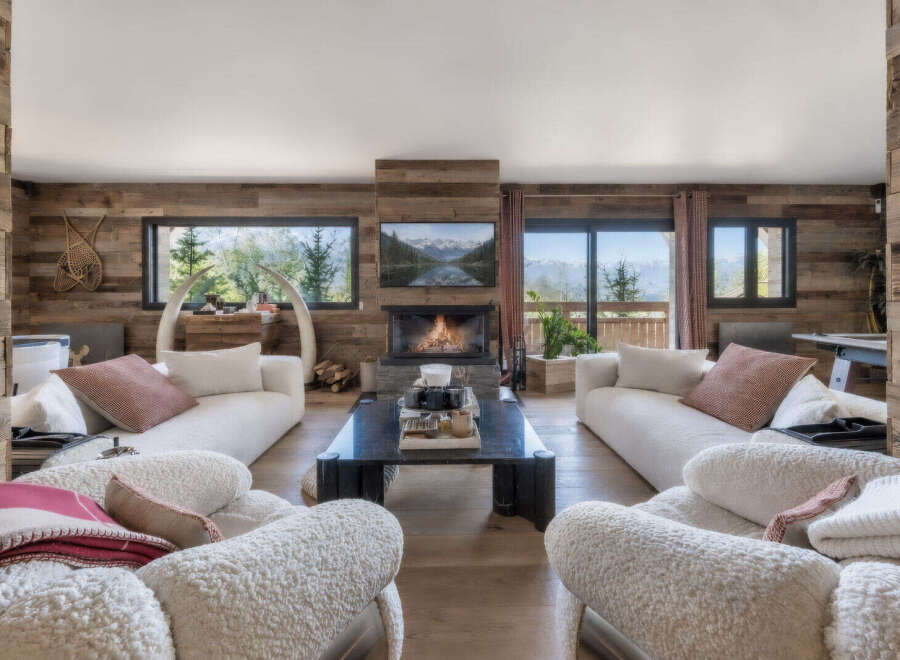 Experience luxurious mountain living in this stunning living room, featuring a modern fireplace and expansive windows that showcase breathtaking alpine views.