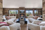 Experience luxurious mountain living in this stunning living room, featuring a modern fireplace and expansive windows that showcase breathtaking alpine views.