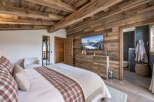 Experience rustic luxury in this charming bedroom, featuring a cozy bed adorned with plaid accents and a soft throw.