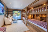 Experience ultimate comfort in this charming children's bedroom, featuring a cozy bunk bed setup with red and white plaid bedding.